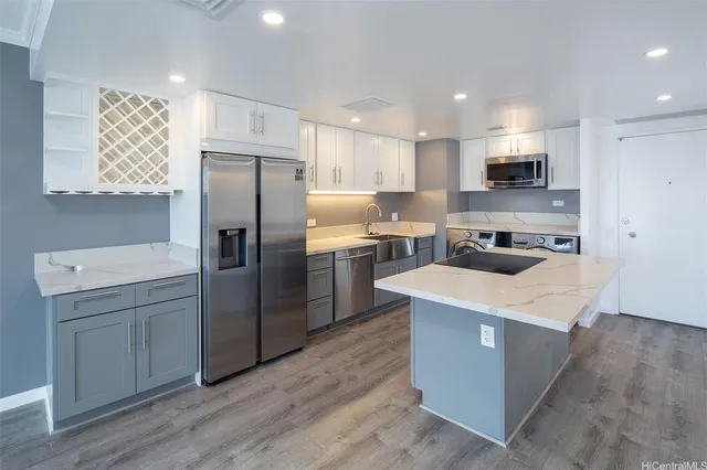 a kitchen with kitchen island a sink stainless steel appliances and refrigerator
