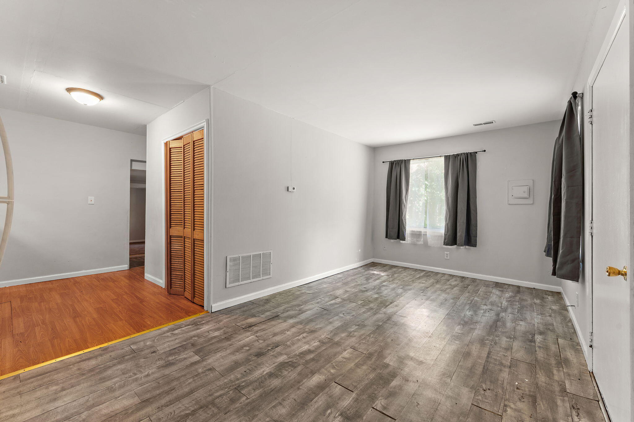 1910 South Calhoun Street Griffith, IN 46319 - Photo 7 of 34 a view of an empty room with wooden floor and a window