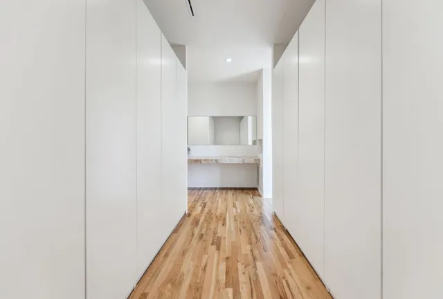 a spacious bedroom with a bed and a wooden floor