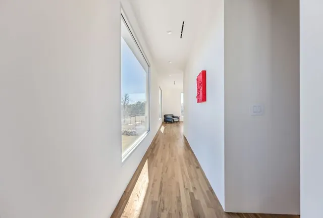 a spacious bedroom with a bed and wooden floor