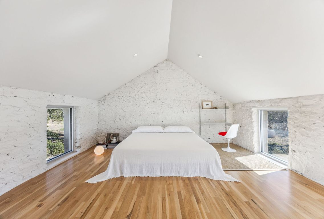 1037 Ranch Road 962 West Round Mountain, TX 78663 - Photo 24 of 40 a spacious bedroom with a bed and wooden floor