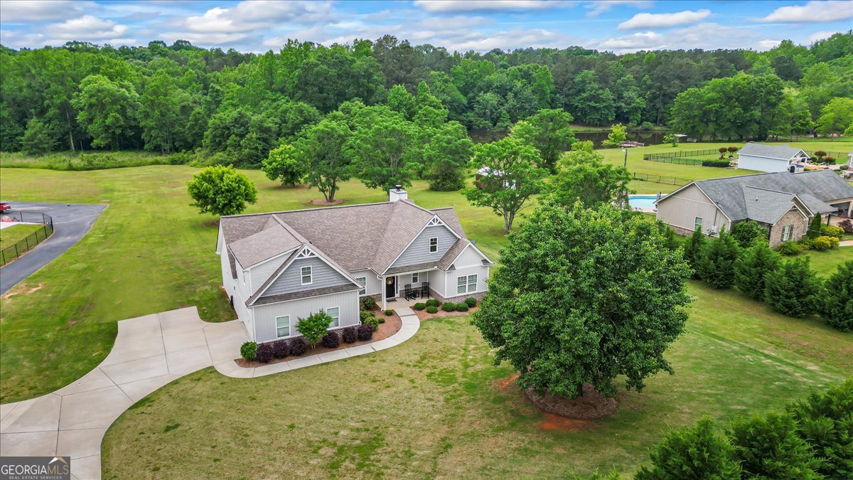an aerial view of a house with swimming pool garden and patio