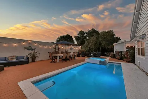 a view of a patio with swimming pool and sitting area