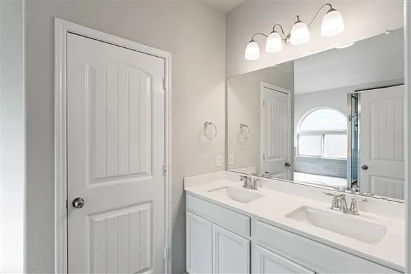 a bathroom with a tub a sink and a large mirror