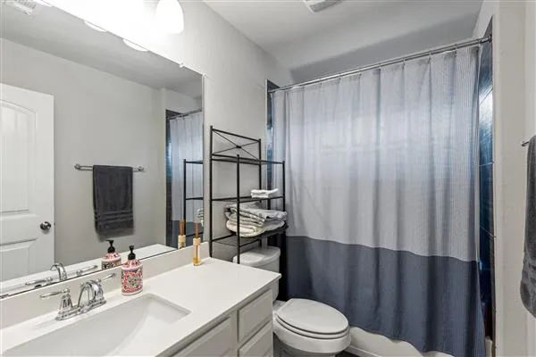 a view of an empty room and bathroom with furniture