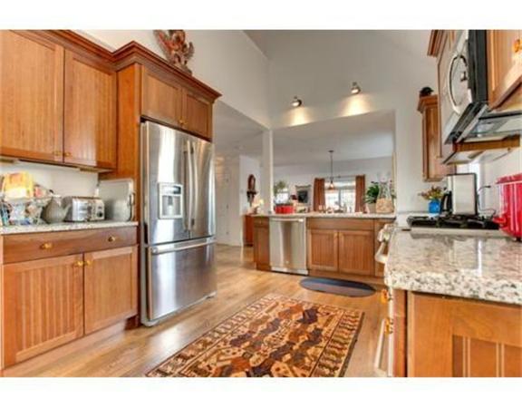 15 D Trail Ridge Way, Unit 52 Harvard, MA 01451 - Photo 10 of 29 a kitchen with stainless steel appliances granite countertop a refrigerator a stove a sink and a microwave with wooden floor