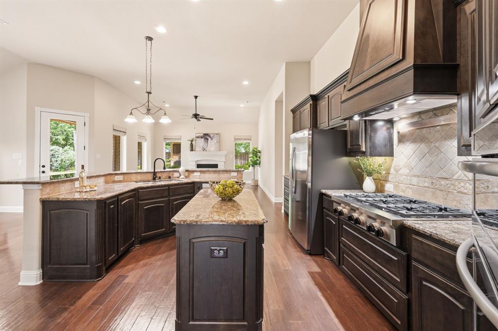 7013 Handel Colleyville, TX 76034 - Photo 13 of 37 Gourmet kitchen featuring wood-finish flooring, dark wood cabinetry, and granite countertops