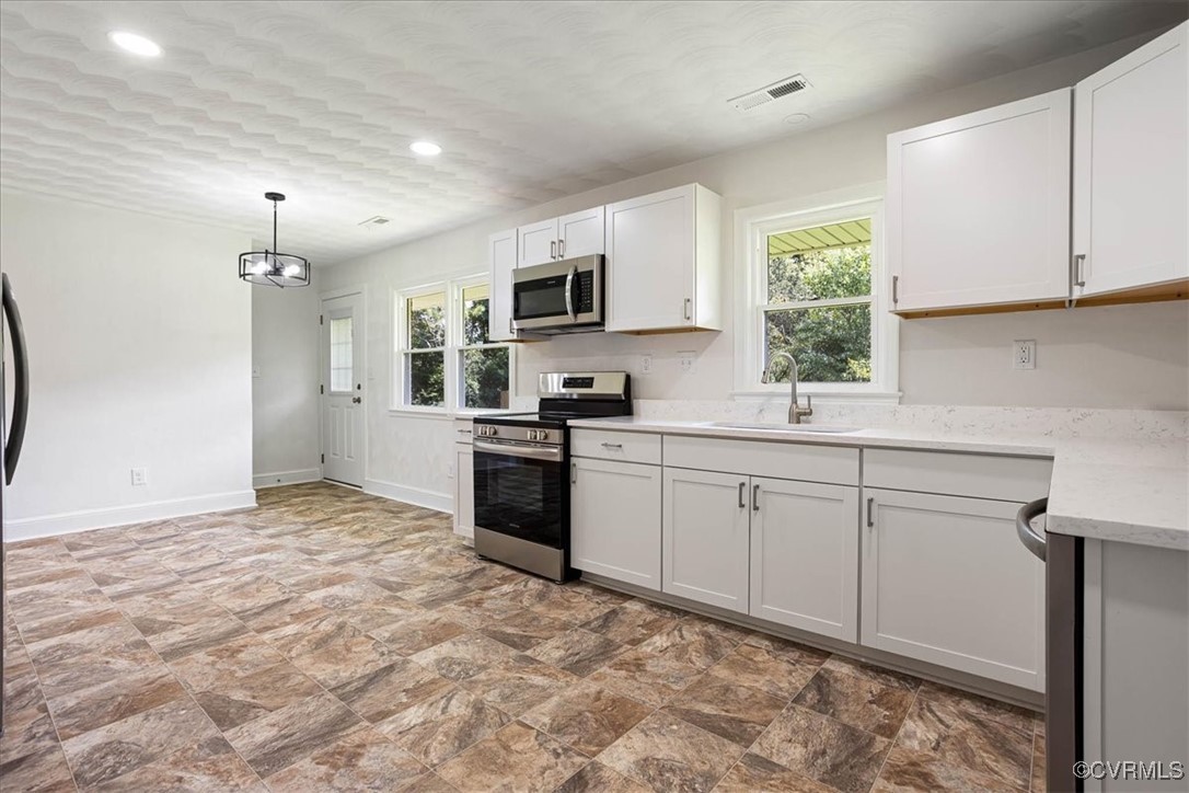 113 Beaver Dam Road Waverly, VA 23890 - Photo 14 of 34 Kitchen with white cabinetry, sink, hanging light