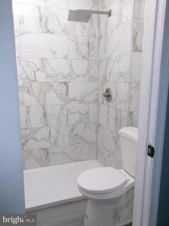 a bathroom with a toilet and a shower