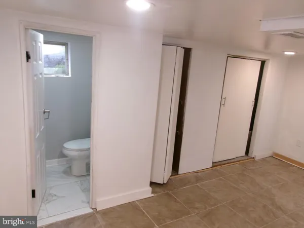 a bathroom with a granite countertop toilet and a sink