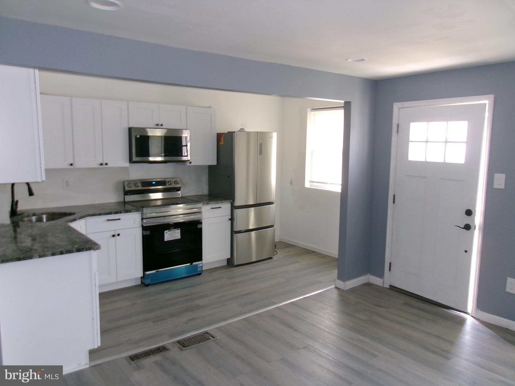 1017 Barker Road Sharon Hill, PA 19079 - Photo 2 of 20 a kitchen with granite countertop a refrigerator and a stove top oven