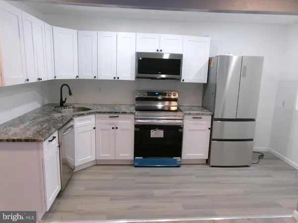 a kitchen with stainless steel appliances granite countertop a stove a refrigerator and a microwave