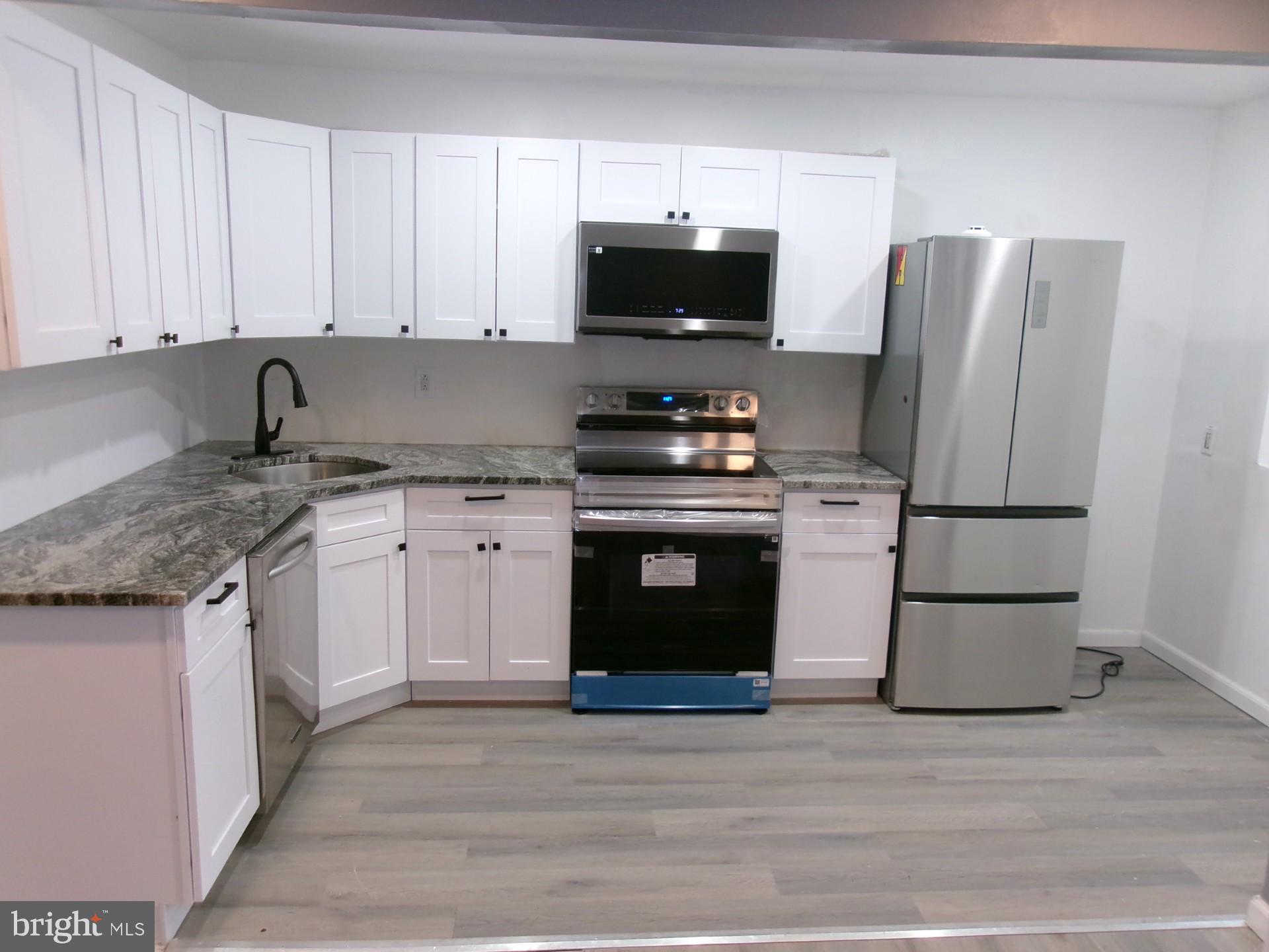 1017 Barker Road Sharon Hill, PA 19079 - Photo 4 of 20 a kitchen with stainless steel appliances granite countertop a stove a refrigerator and a microwave