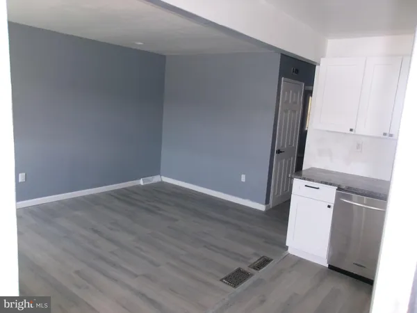 an empty room with wooden floor and white wall