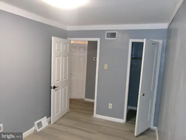 an empty room with wooden floor and closet