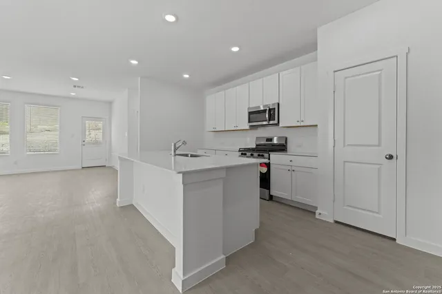 a kitchen with white cabinets and stainless steel appliances