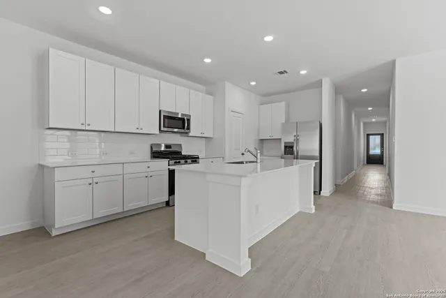a view of kitchen with white cabinets stainless steel appliances and a refrigerator