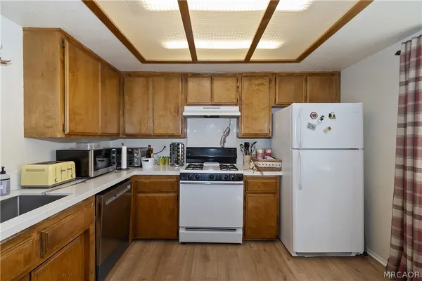 a kitchen with a refrigerator a stove a microwave and wooden floor