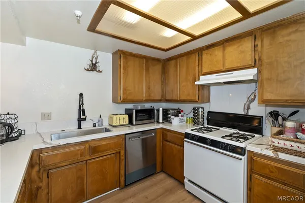 a kitchen with stainless steel appliances a sink stove and cabinets