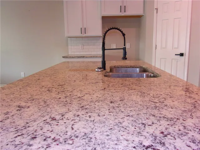 a large kitchen with stainless steel appliances granite countertop a large stove a sink dishwasher and a refrigerator with wooden floor