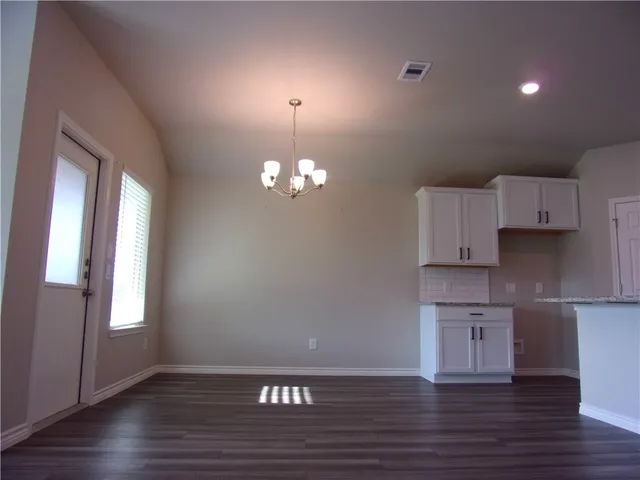 a dining room with chandelier wooden floor and a chandelier