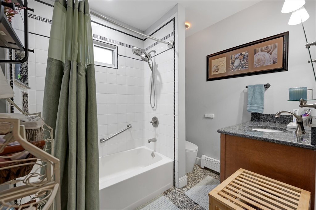 156 Olean Street Worcester, MA 01602 - Photo 18 of 37 a bathroom with a sink a toilet a shower curtain and a bath tub