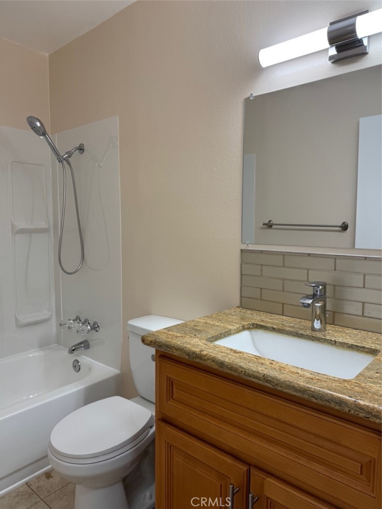 1115 Clark Street Riverside, CA 92501 - Photo 15 of 24 a bathroom with a granite countertop sink a toilet and shower