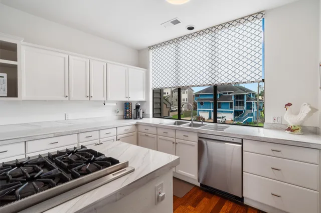a kitchen with stainless steel appliances granite countertop a sink a stove and a refrigerator