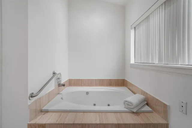 a bathroom with a tub and window