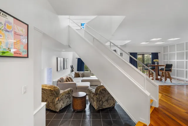 a living room with furniture and view of kitchen