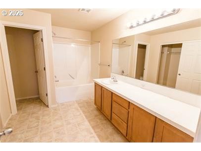 12820 Southwest Dipper Lane, Unit 100 Beaverton, OR 97007 - Photo 13 of 18 a spacious bathroom with a double vanity sink a mirror and a bathtub