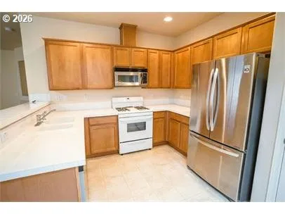 a kitchen with stainless steel appliances a refrigerator sink and microwave