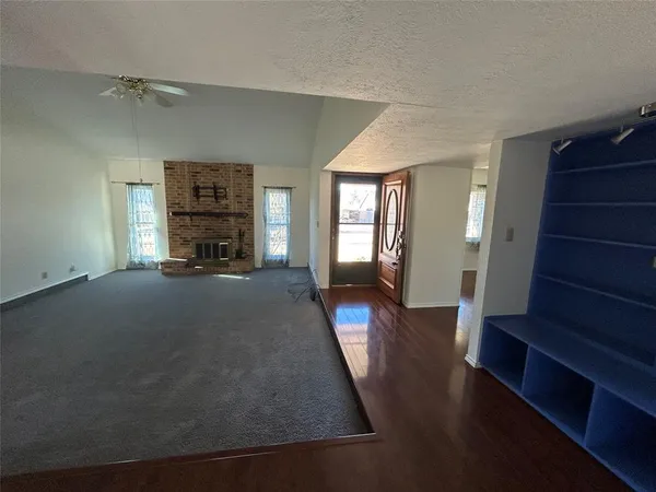 an empty room with a ceiling fan and wooden floor