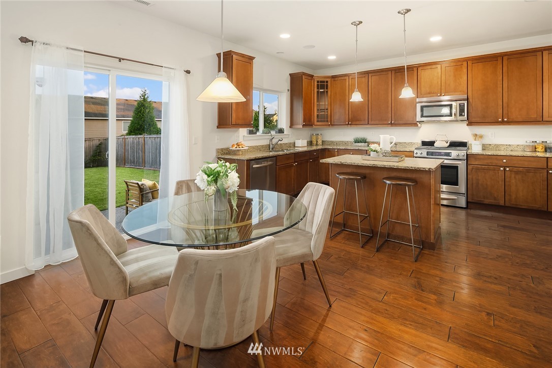 3728 224th Street Southeast Bothell, WA 98021 - Photo 4 of 22 a kitchen with a table chairs refrigerator and cabinets
