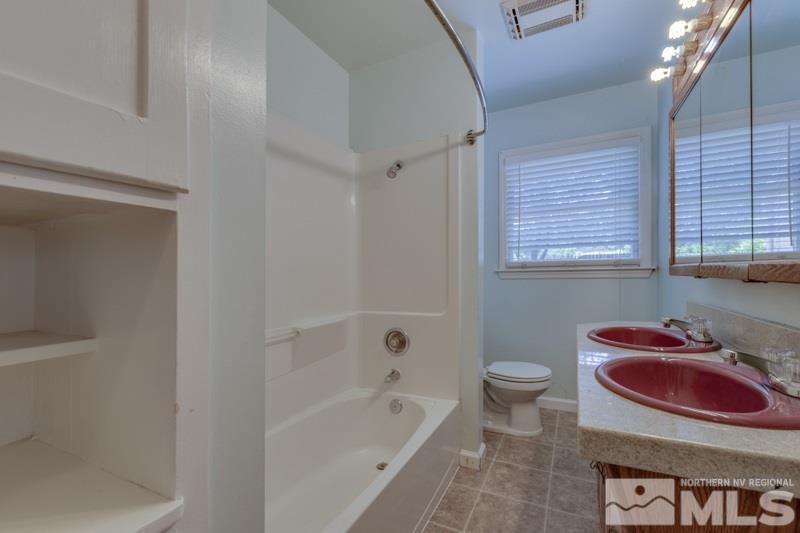 935 Vine Street Reno, NV 89503 - Photo 10 of 18 a bath room with a toilet a bath tub and a shower