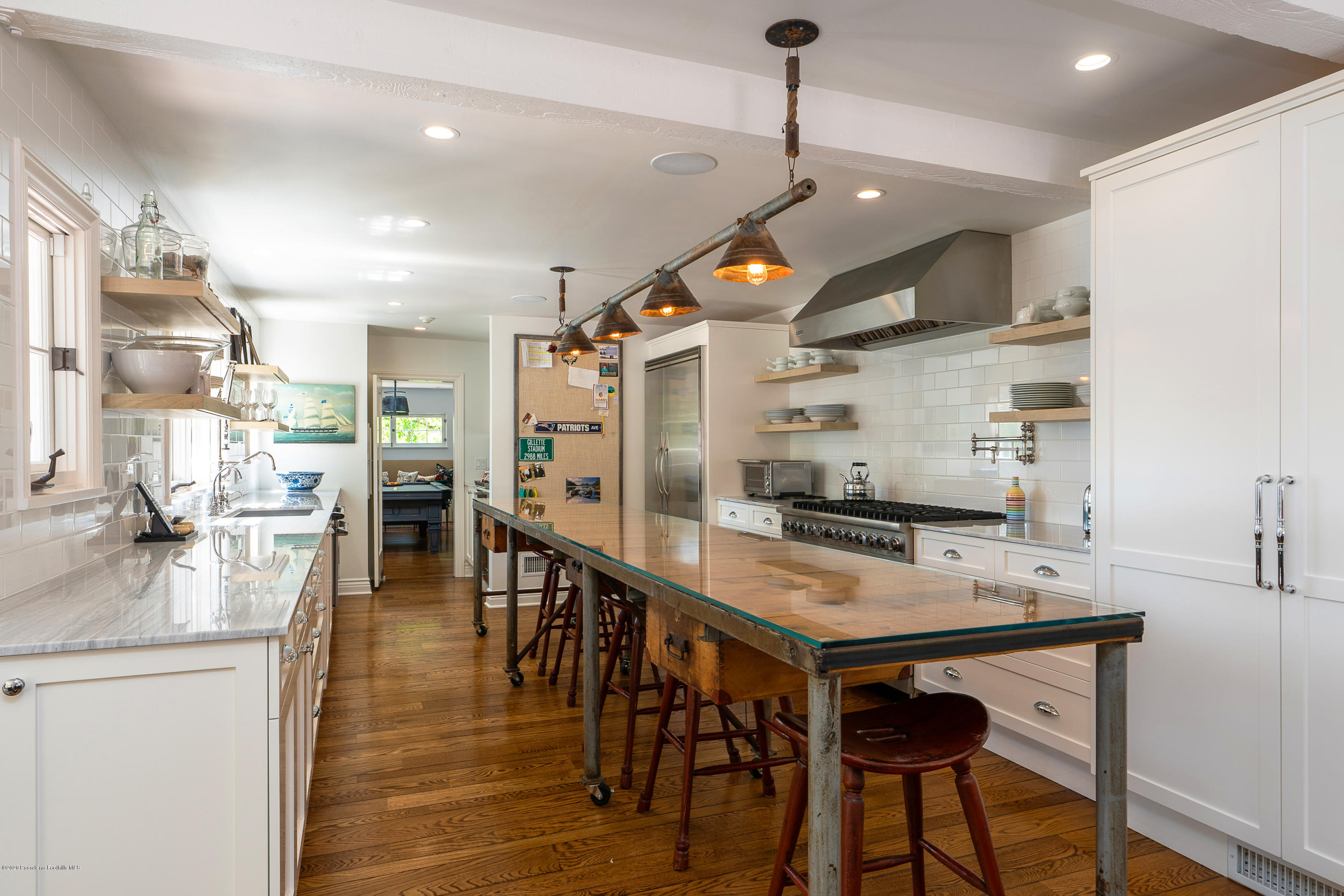 700 Laguna Road Pasadena, CA 91105 - Photo 9 of 31 a kitchen with stainless steel appliances kitchen island granite countertop a stove a refrigerator a oven a sink a dining table and chairs with wooden floor