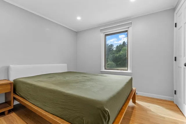 a bedroom with a bed and wooden floor