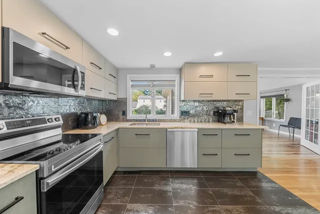a kitchen with granite countertop a sink stainless steel appliances and cabinets