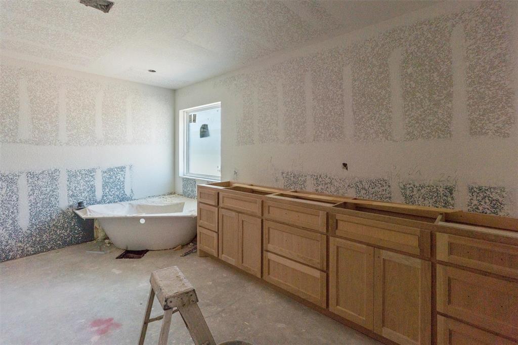 1300 Promised Land Road Hewitt, TX 76643 - Photo 26 of 34 Freestanding soaking tub, window, and extensive cabinetry