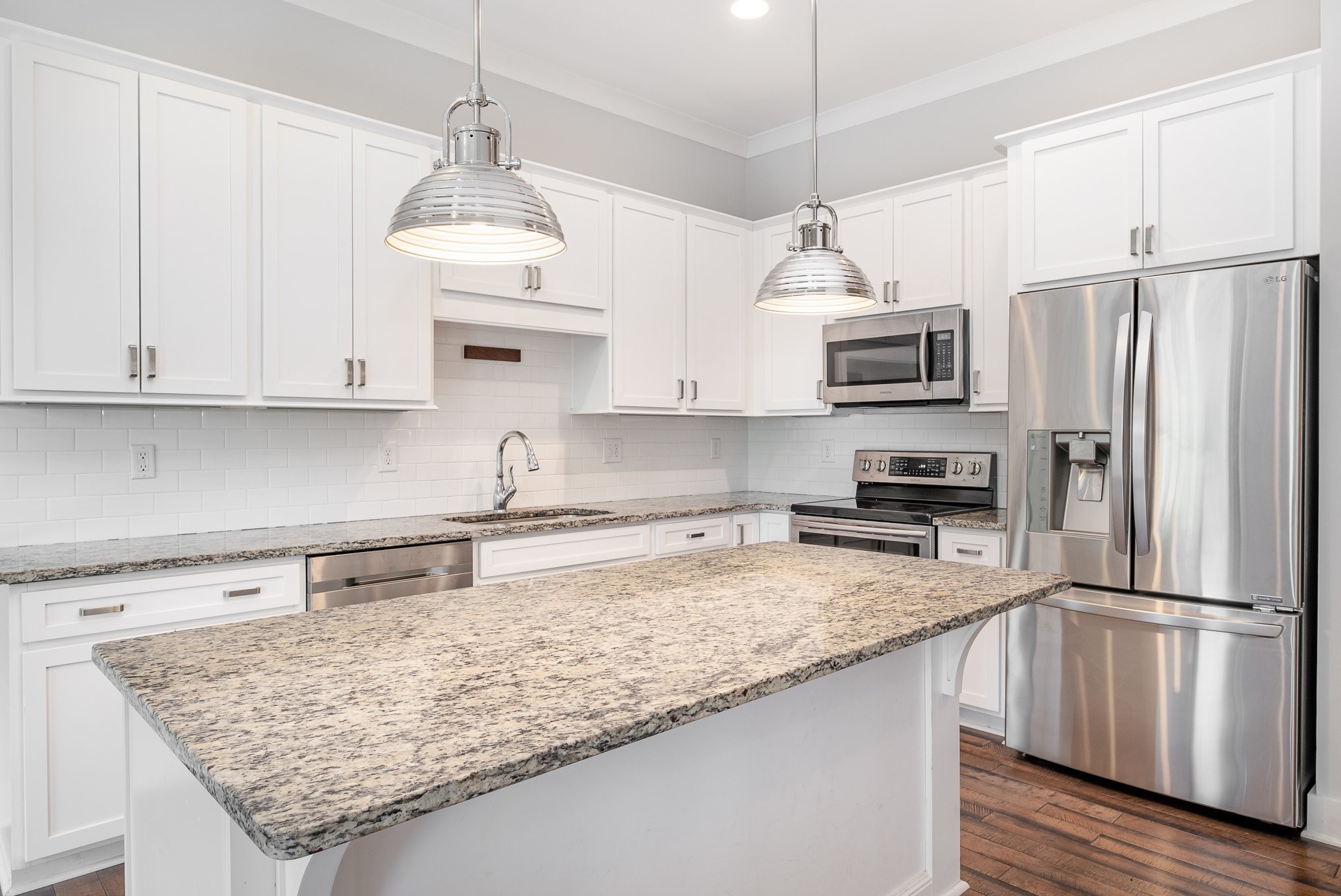 1106 Wade Avenue, Unit 5 Nashville, TN 37203 - Photo 13 of 33 a kitchen with kitchen island granite countertop a sink stainless steel appliances and white cabinets