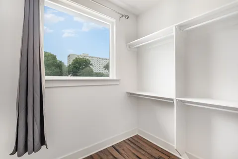 a view of a small space with wooden floor and a window