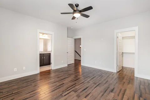 a view of a room with wooden floor and a ceiling fan