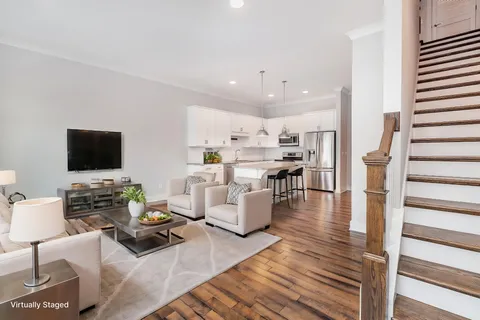 a living room with furniture kitchen view and a flat screen tv