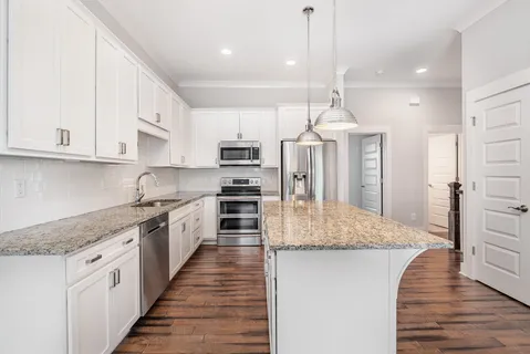 a kitchen with stainless steel appliances granite countertop a sink a stove and a refrigerator