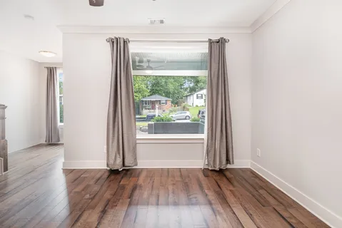 an empty room with wooden floor and a window