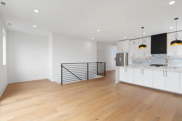 a view of an empty room with kitchen appliances and a window