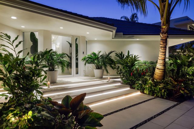 a front view of multi story residential apartment building with yard and sign board