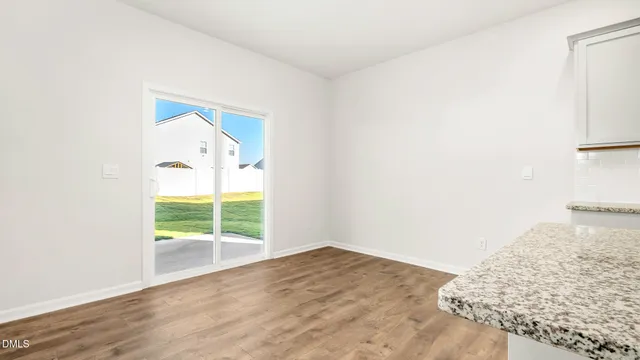 a view of an empty room with a window and fireplace