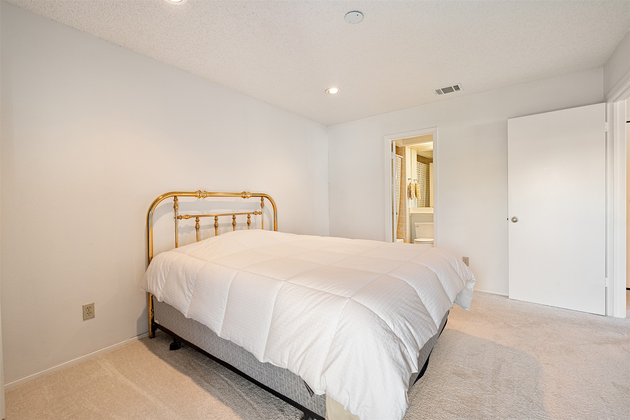1748 Ohlen Road, Unit 16 Austin, TX 78757 - Photo 19 of 38 Bedroom with recessed lighting, light colored carpet, ensuite bathroom, and a textured ceiling