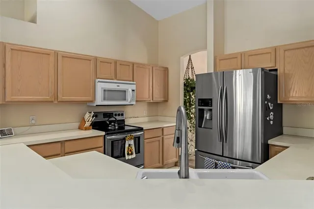 a kitchen with stainless steel appliances granite countertop a refrigerator and a stove